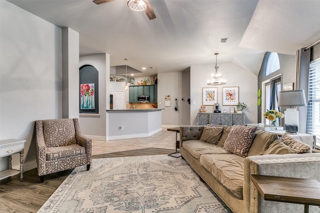 7916 Stansfield Dr, Fort Worth, TX 76137 - living room featuring baseboards, visible vents, light tile patterned flooring, ceiling fan with notable chandelier, and vaulted ceiling