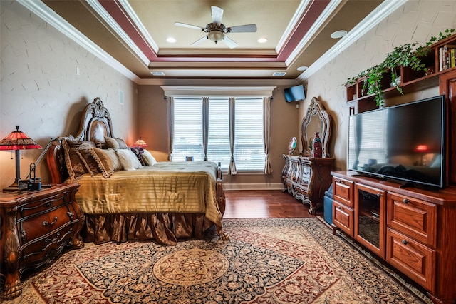bedroom featuring dark wood-style flooring, a raised ceiling, crown molding, and ceiling fan