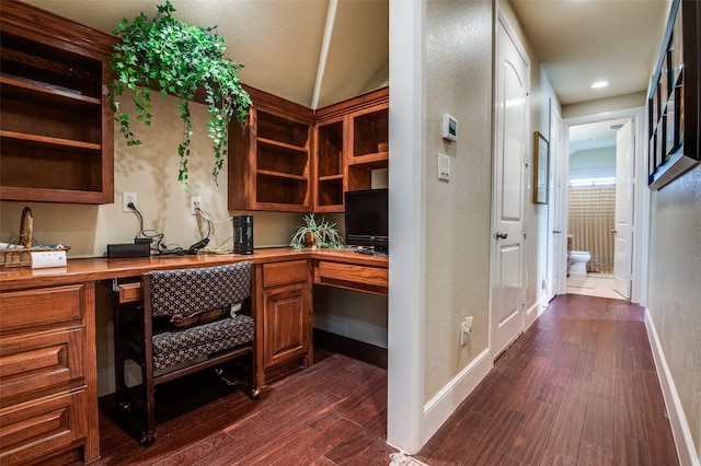 home office with built in study area, dark wood-style flooring, baseboards, and a textured wall