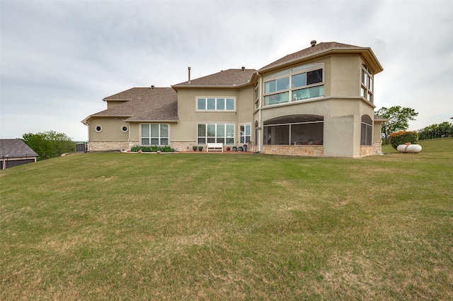rear view of house with a lawn, central air condition unit, stucco siding, and a shingled roof