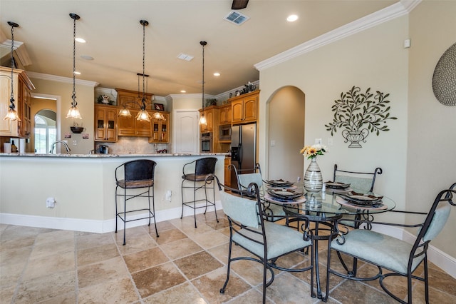 dining space with crown molding, arched walkways, visible vents, and recessed lighting