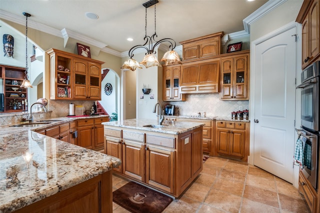 kitchen with a sink, brown cabinetry, and arched walkways