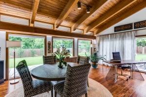 dining area featuring lofted ceiling with beams, wood ceiling, and wood finished floors