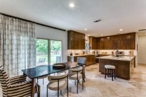 kitchen with dark brown cabinets, light countertops, recessed lighting, and a kitchen island