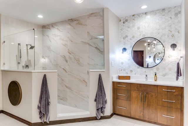 bathroom with a marble finish shower, baseboards, vanity, and recessed lighting