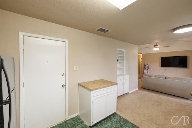3749 Oldham Ln, Abilene, TX 79602 - kitchen with freestanding refrigerator, white cabinetry, dark colored carpet, and visible vents