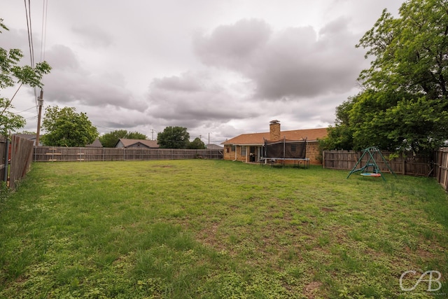 3749 Oldham Ln, Abilene, TX 79602 - view of yard featuring a fenced backyard, a playground, and a trampoline