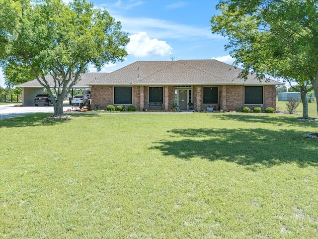 single story home with a shingled roof, a front lawn, brick siding, and gravel driveway