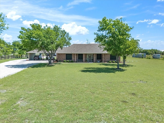 ranch-style house with fence, a front lawn, a shingled roof, brick siding, and gravel driveway