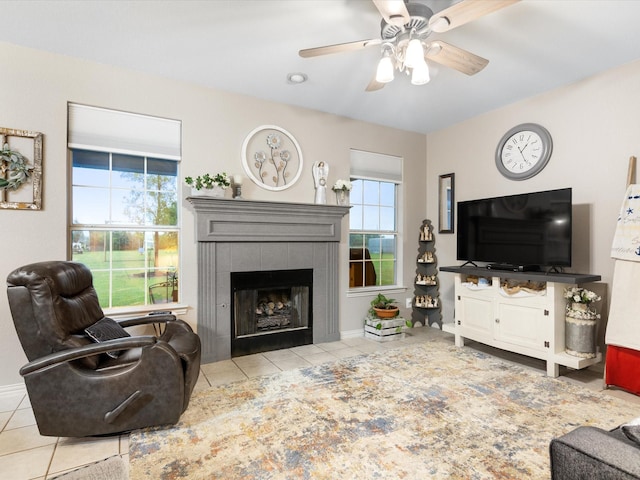 living room with baseboards, tile patterned floors, a fireplace, and ceiling fan