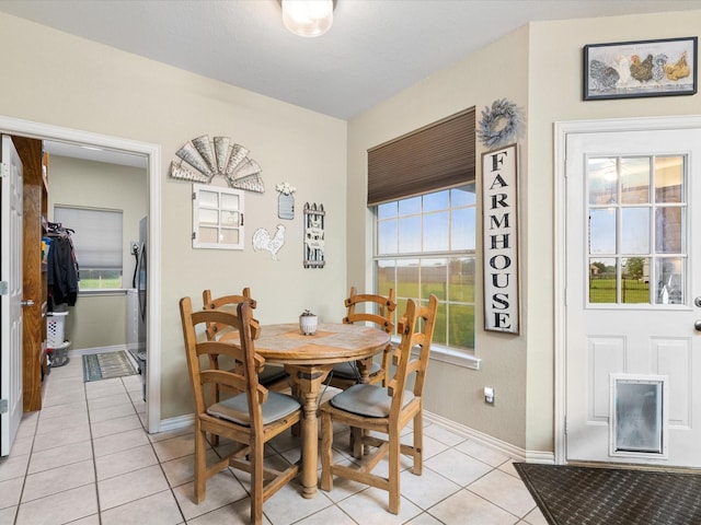dining space featuring light tile patterned floors and baseboards
