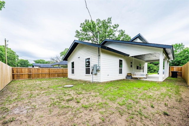 rear view of house with a lawn, a patio, and a fenced backyard