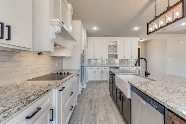 kitchen with white cabinets, dishwasher, black electric stovetop, and a sink