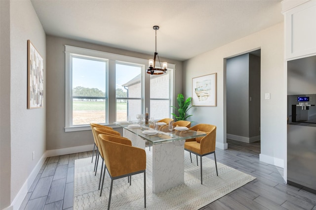 dining room featuring wood finished floors, a chandelier, and baseboards