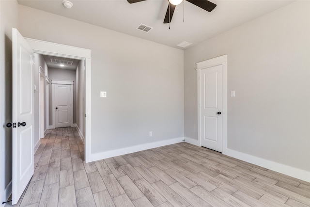 unfurnished room featuring light wood finished floors, baseboards, a ceiling fan, and visible vents