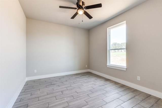 spare room featuring a ceiling fan, baseboards, and wood finished floors