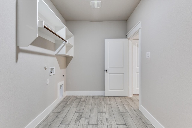 clothes washing area with laundry area, light wood-type flooring, hookup for a gas dryer, electric dryer hookup, and washer hookup