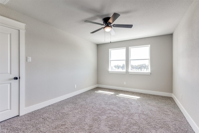 carpeted spare room with baseboards and ceiling fan