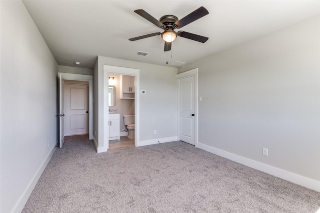 unfurnished bedroom featuring a ceiling fan, baseboards, visible vents, connected bathroom, and light colored carpet
