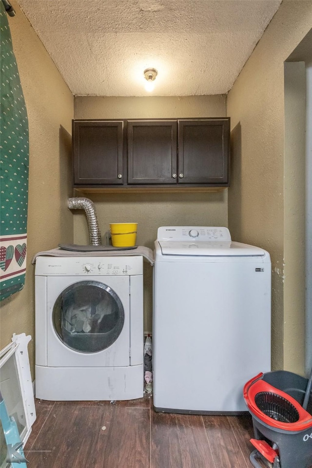 clothes washing area with separate washer and dryer, cabinet space, a textured ceiling, and dark wood-type flooring