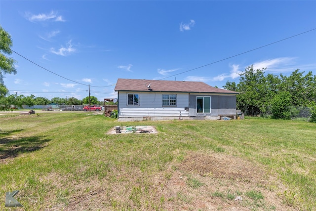 rear view of house featuring a yard