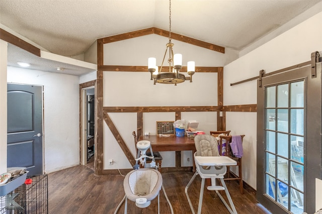 dining room featuring wood finished floors, vaulted ceiling, a chandelier, a barn door, and a textured ceiling