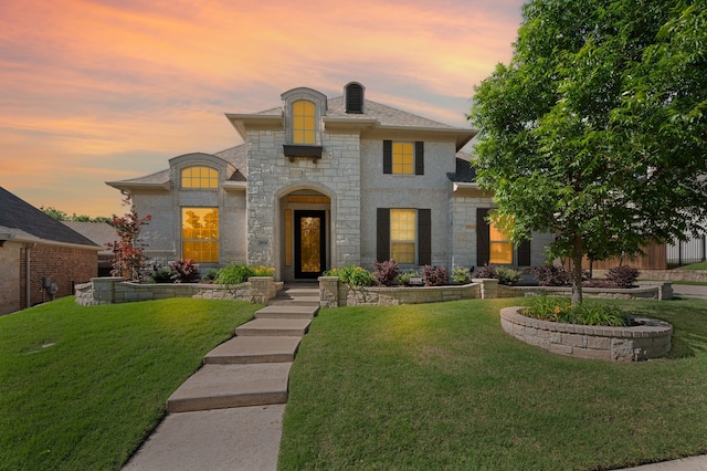 french country home with a front lawn and stone siding