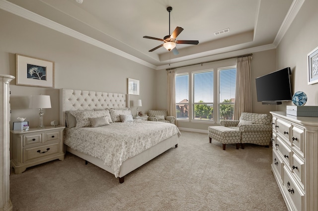 bedroom with a raised ceiling, light colored carpet, crown molding, and ceiling fan