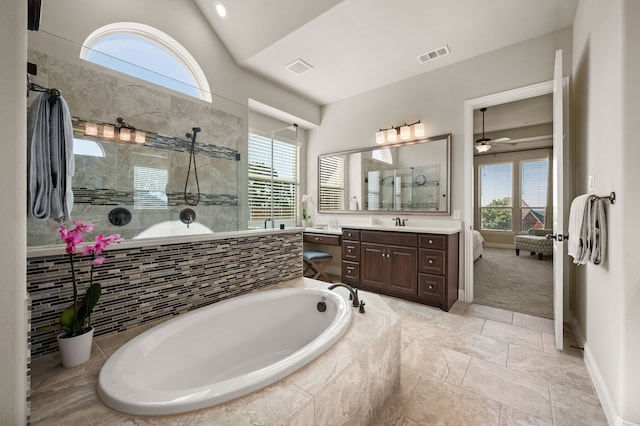 full bath with tiled shower, a bath, vanity, a ceiling fan, and vaulted ceiling