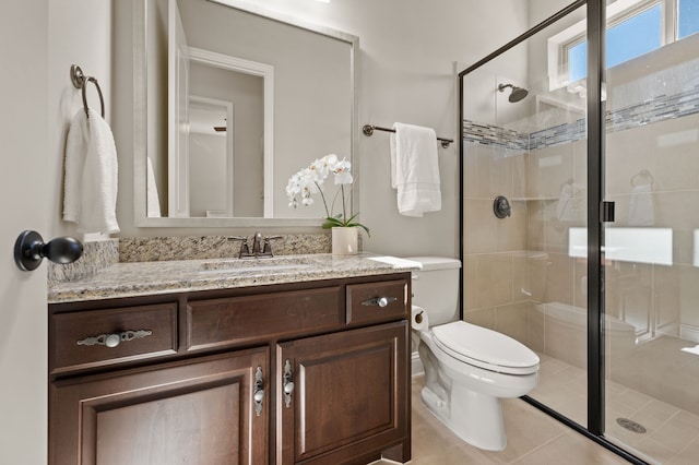 bathroom featuring a stall shower, vanity, toilet, and tile patterned flooring