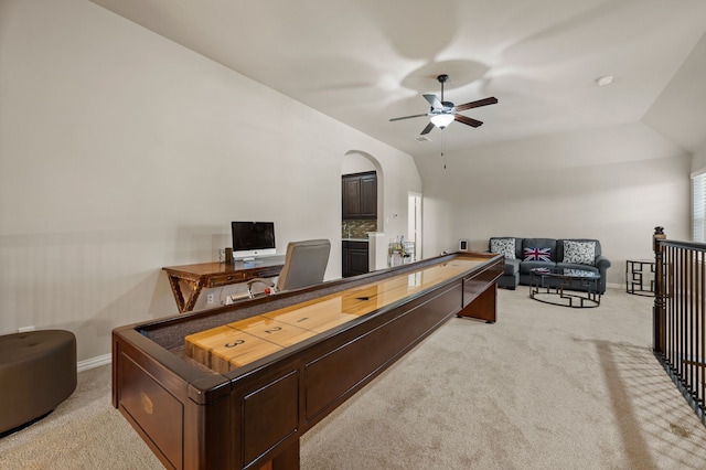 office area featuring light colored carpet, a ceiling fan, baseboards, and lofted ceiling