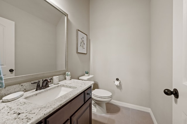 bathroom with toilet, tile patterned floors, baseboards, and vanity