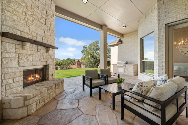 view of patio with an outdoor kitchen and an outdoor living space with a fireplace