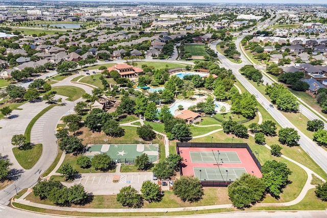 aerial view of residential area featuring a nearby body of water and a pool area
