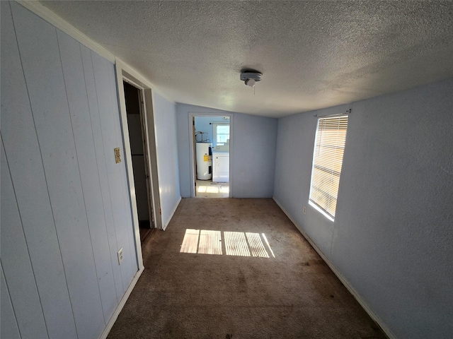 hall featuring a textured ceiling, washer / clothes dryer, water heater, and carpet