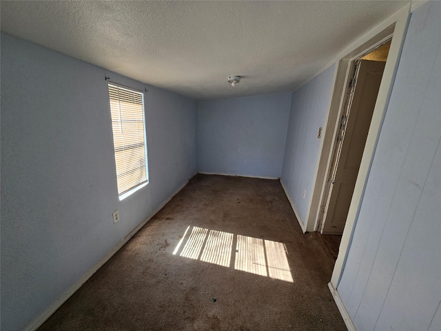 carpeted empty room featuring a textured ceiling