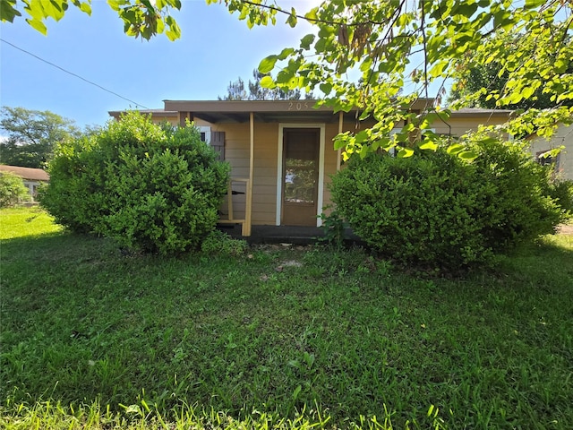 back of property featuring a lawn