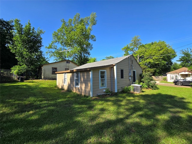 view of property exterior with central AC unit and a lawn