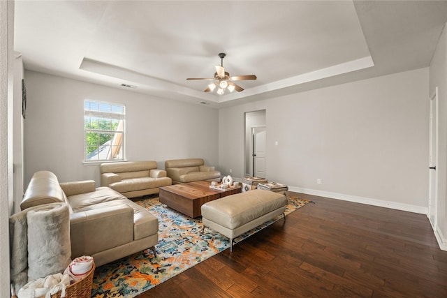living area with a tray ceiling, a ceiling fan, and hardwood / wood-style flooring