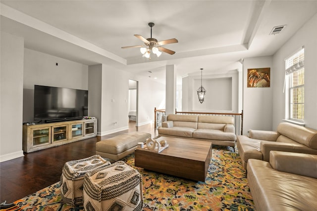 living room with wood finished floors, a ceiling fan, a tray ceiling, visible vents, and baseboards