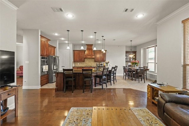 living room featuring light wood finished floors, baseboards, visible vents, and recessed lighting