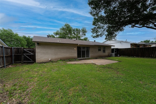 rear view of house with a patio, cooling unit, a fenced backyard, a yard, and brick siding