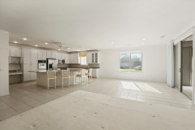kitchen featuring light tile patterned floors, recessed lighting, a breakfast bar area, and appliances with stainless steel finishes