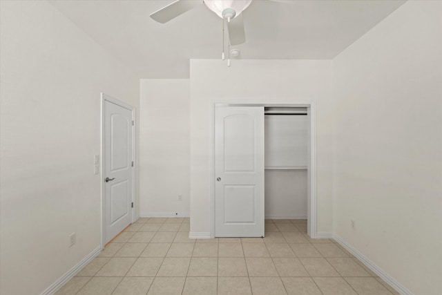 unfurnished bedroom featuring baseboards, ceiling fan, a closet, and light tile patterned flooring