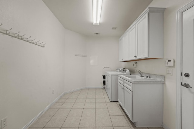 laundry area with cabinet space, washing machine and dryer, baseboards, and a sink