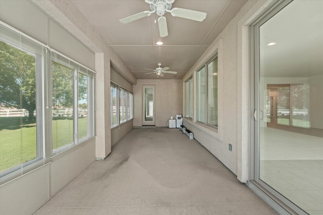 unfurnished sunroom featuring carpet flooring, ceiling fan, and recessed lighting
