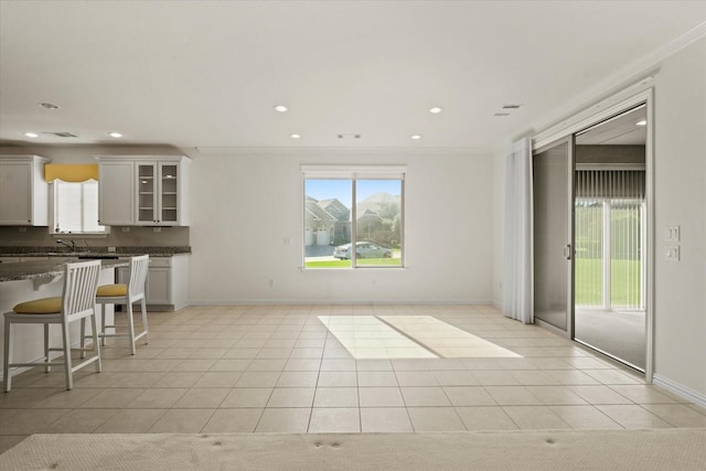 unfurnished living room with light tile patterned floors and crown molding
