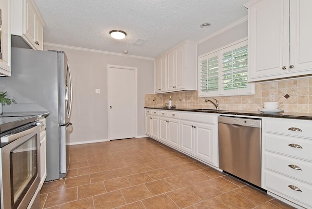 kitchen featuring a sink, dark countertops, stainless steel appliances, white cabinetry, and decorative backsplash