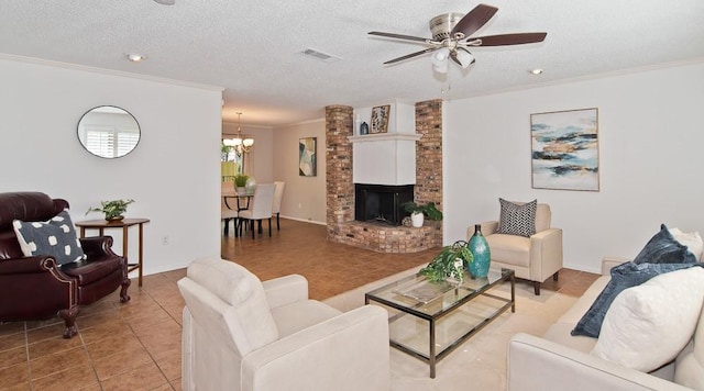 living room featuring ceiling fan with notable chandelier, visible vents, a fireplace, crown molding, and light tile patterned floors