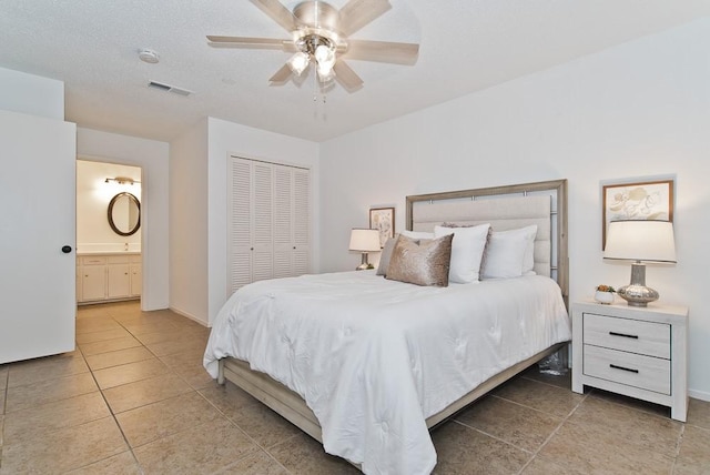 bedroom with tile patterned floors, ensuite bath, a closet, and visible vents